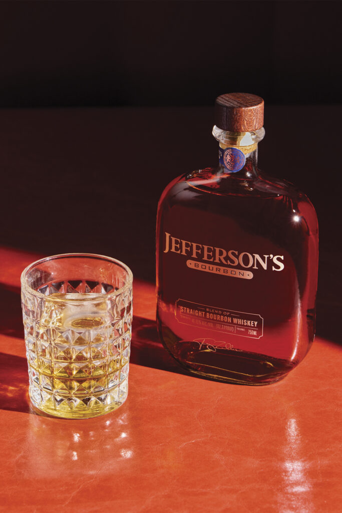 Jefferson's Bourbon on a red table with a glass 