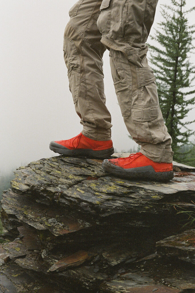 Trip to Alberta to celebrate Citizen Promaster 35-Year Anniversary. shot of waist down shows a hiker on a rock in bright red/orange boots.