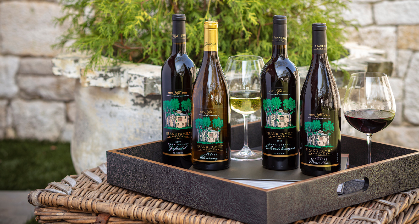 Frank Family Wines profile; a tray with four wine bottles on display and a glass of red wine