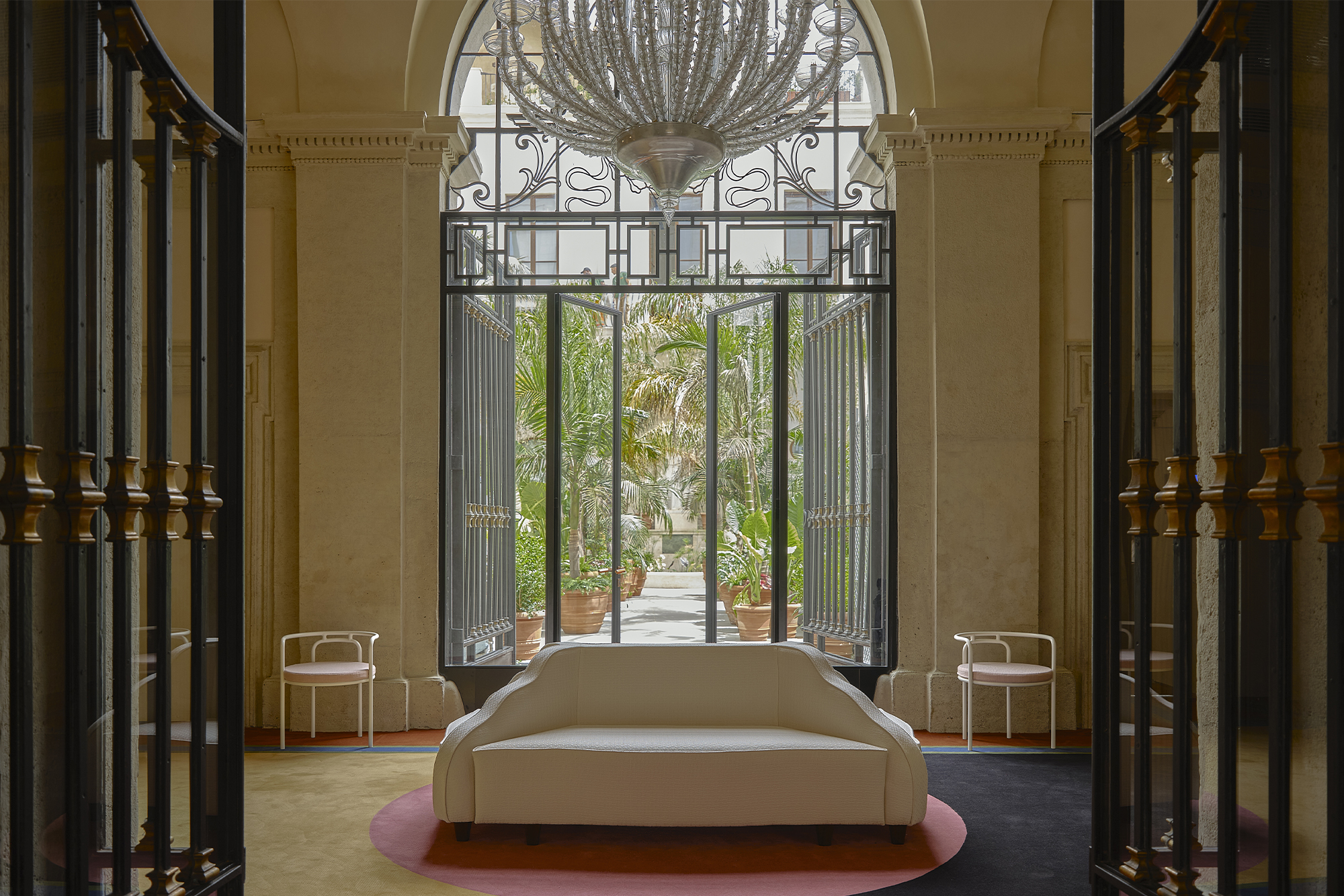 glass chandelier over a white couch with large picture windows