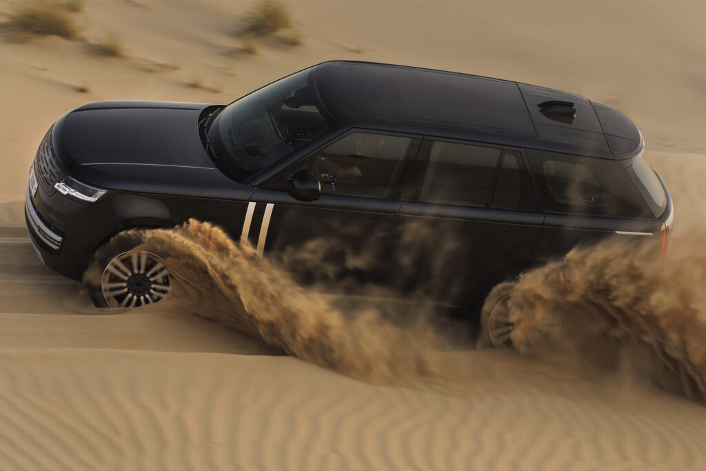 Range Rover Electric driving through the desert, aerial