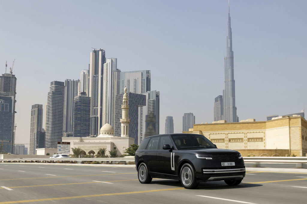 Range Rover Electric parked in an empty lot with skyline in the background