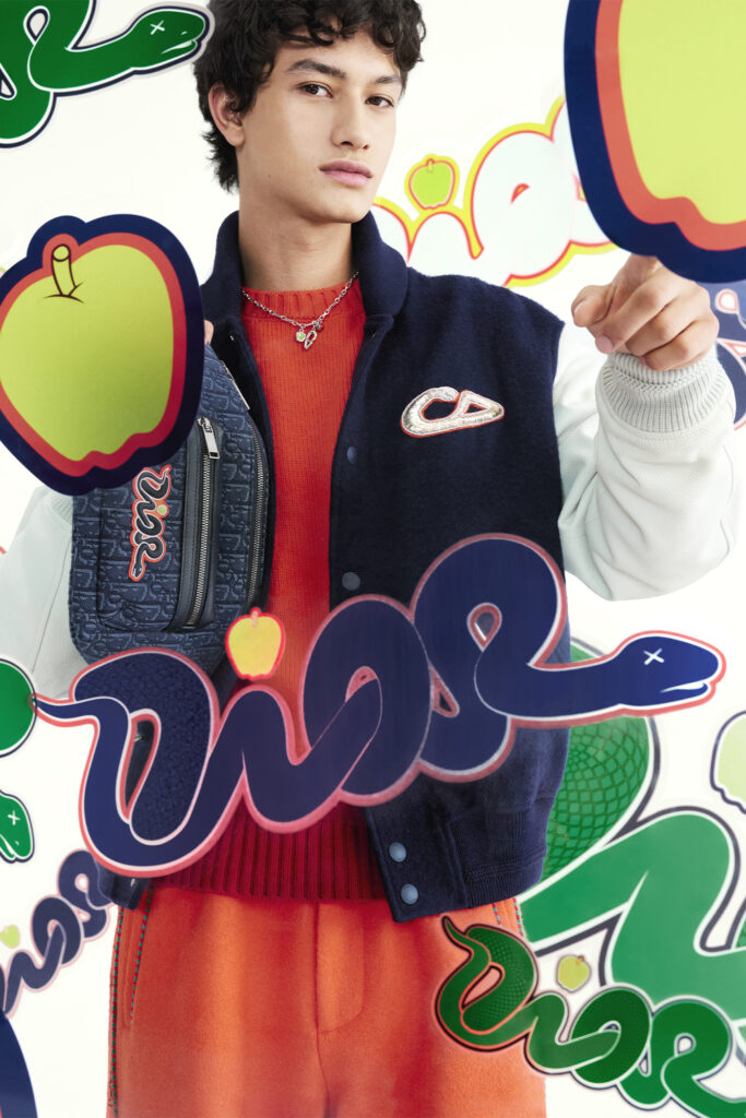 Spring Dior and KAWS Capsule, model shows varsity jacket with graffiti bubble letters in the front