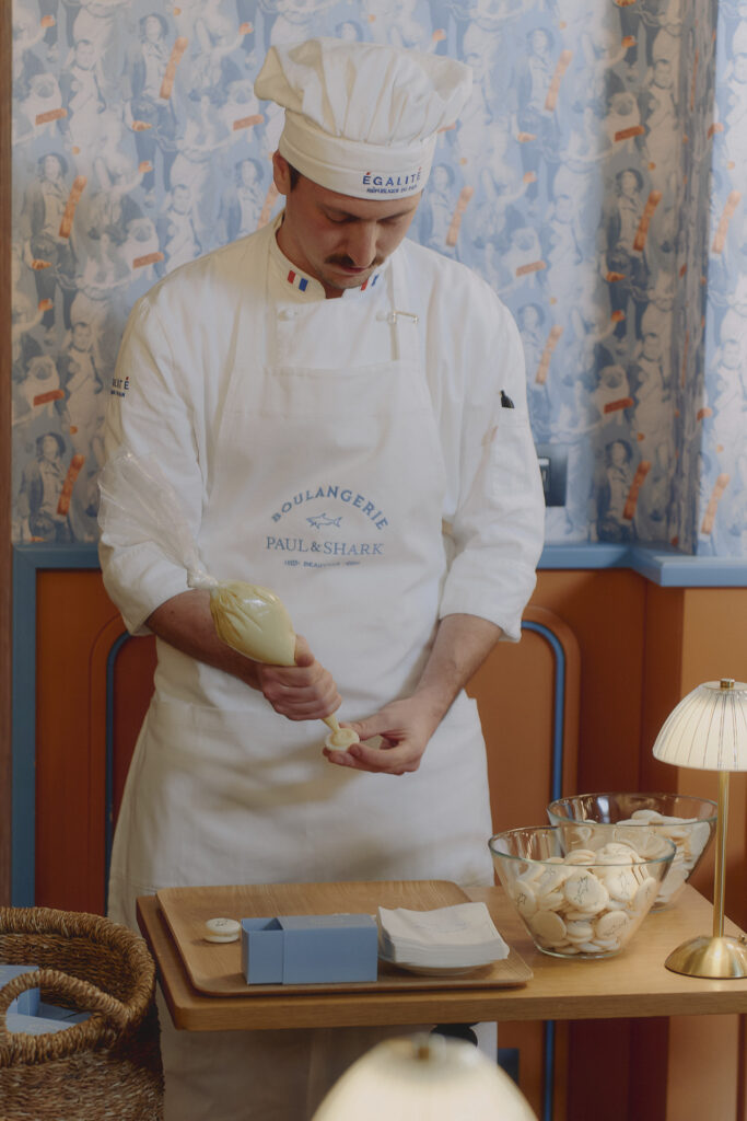 Paul and Shark Men's 2025 Collection chef poses inside french bakery