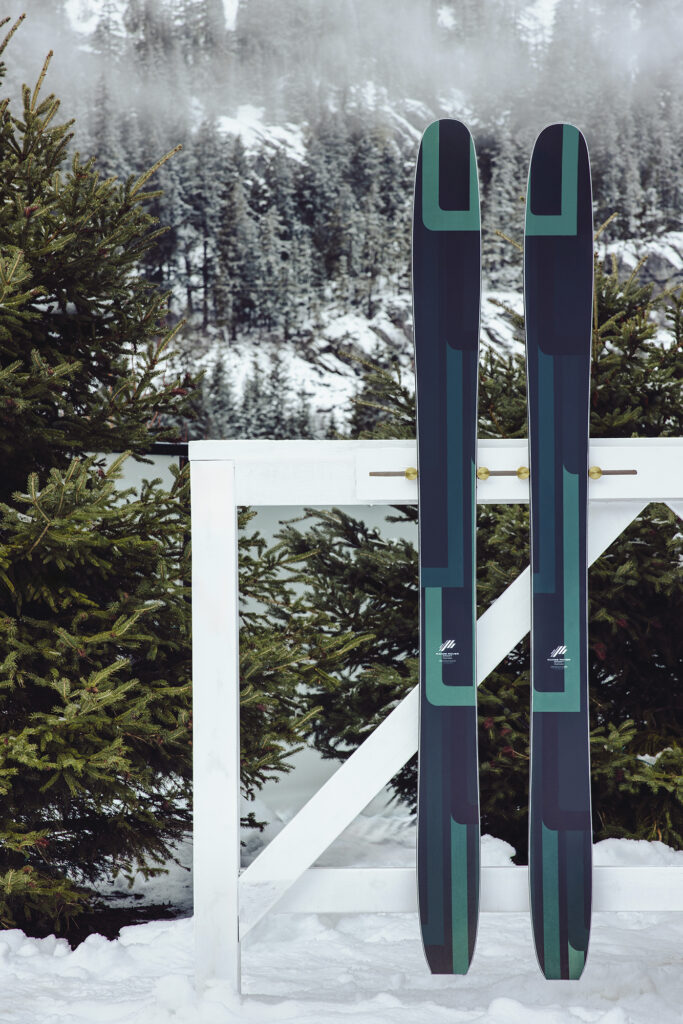 skis propped on a fence at the range rover house whistler