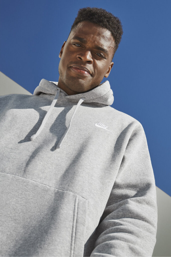 Joe Holder in grey sweatshirt under blue sky. Photo courtesy of Nike.