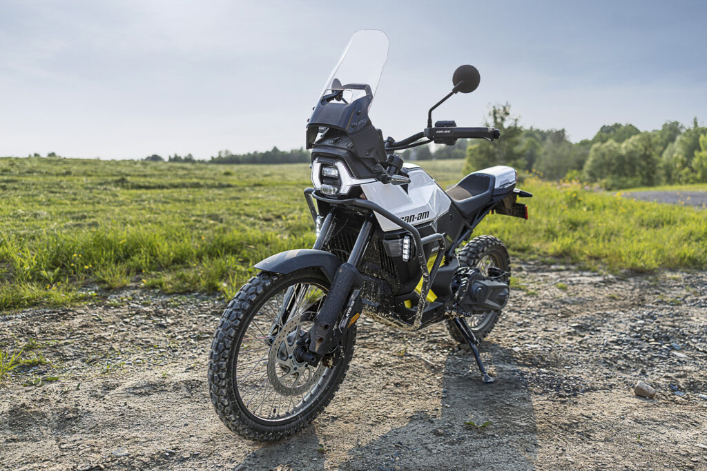 A Can-Am Origin motorcycle is parked on a dirt road