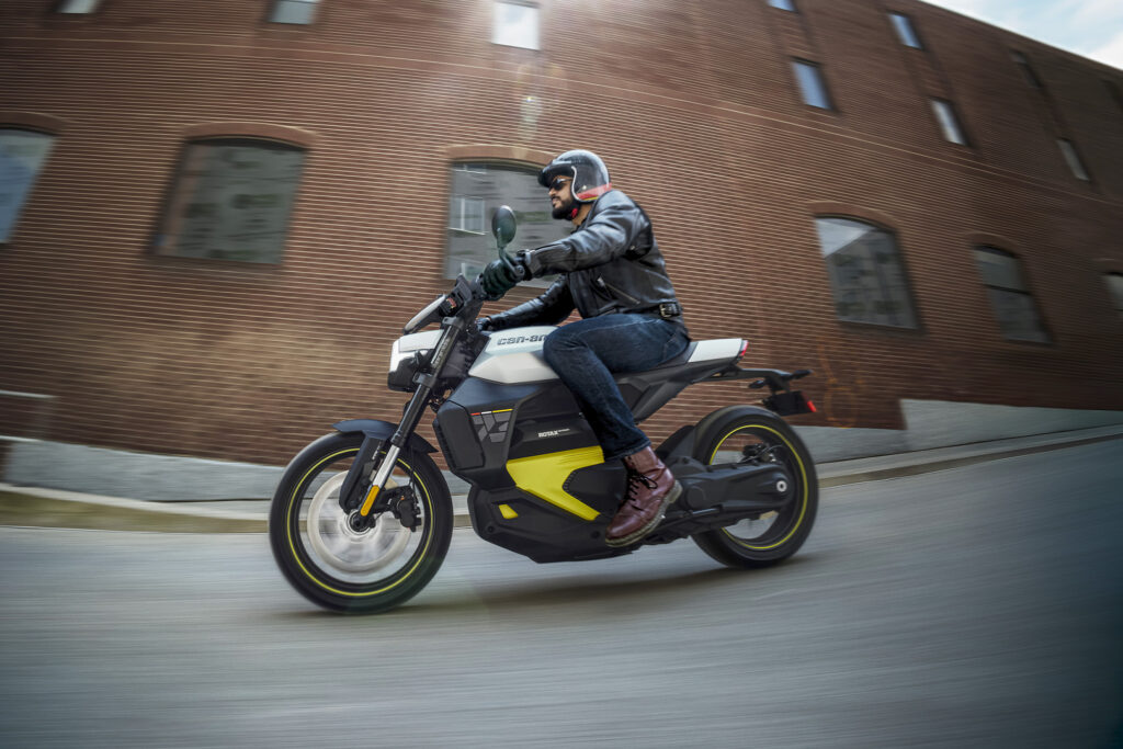 A Can-Am Pulse motorcycle is parked in front of a brick building.