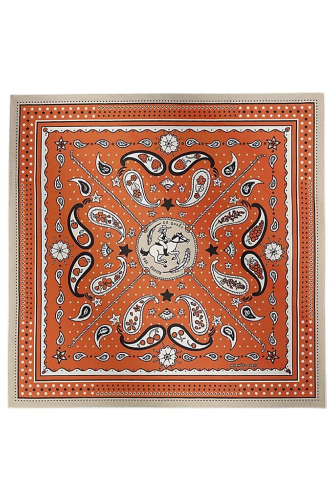 Image shows a silk bandana in orange from Hermes.