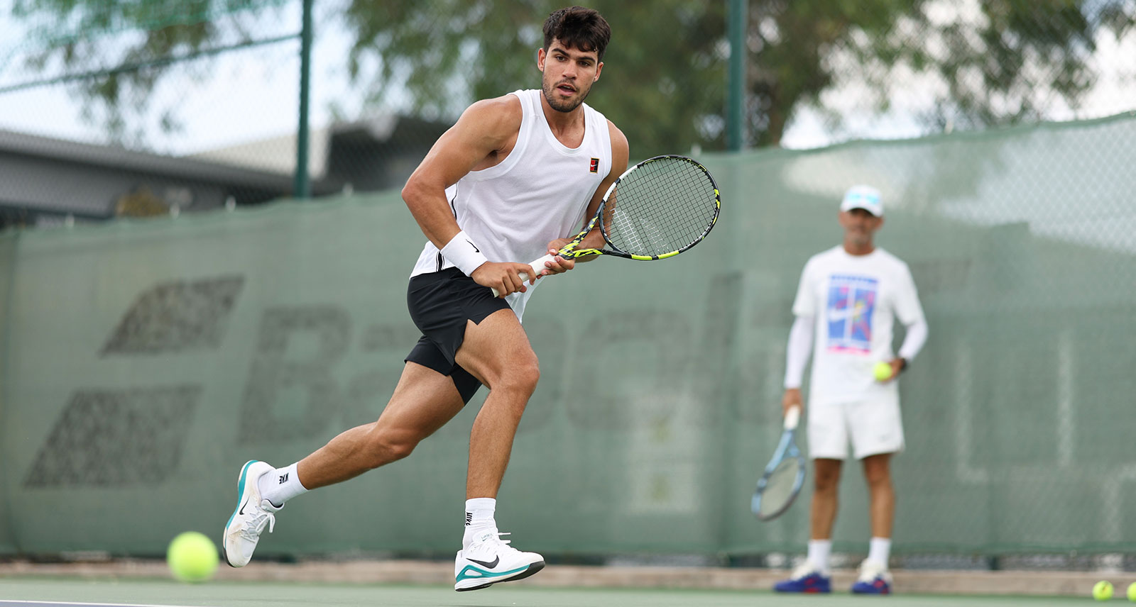 Carlos Alcaraz of Spain runs to play a backhand watched by his coach Samuel Lopez as he trains in preparation for the Cincinnati Open and US Open at Real Sociedad Club de Campo Murcia on July 30, 2025 in Murcia, Spain. (Photo by Clive Brunskill/Getty Images)