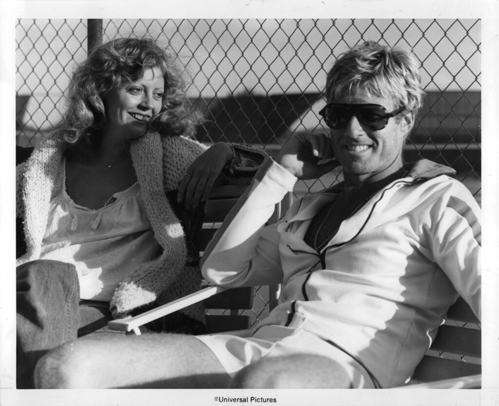 Susan Sarandon and Robert Redford sit on a bench laughing in a scene from the film 'The Great Waldo Pepper', 1975. (Photo by Universal Studios/Getty Images)