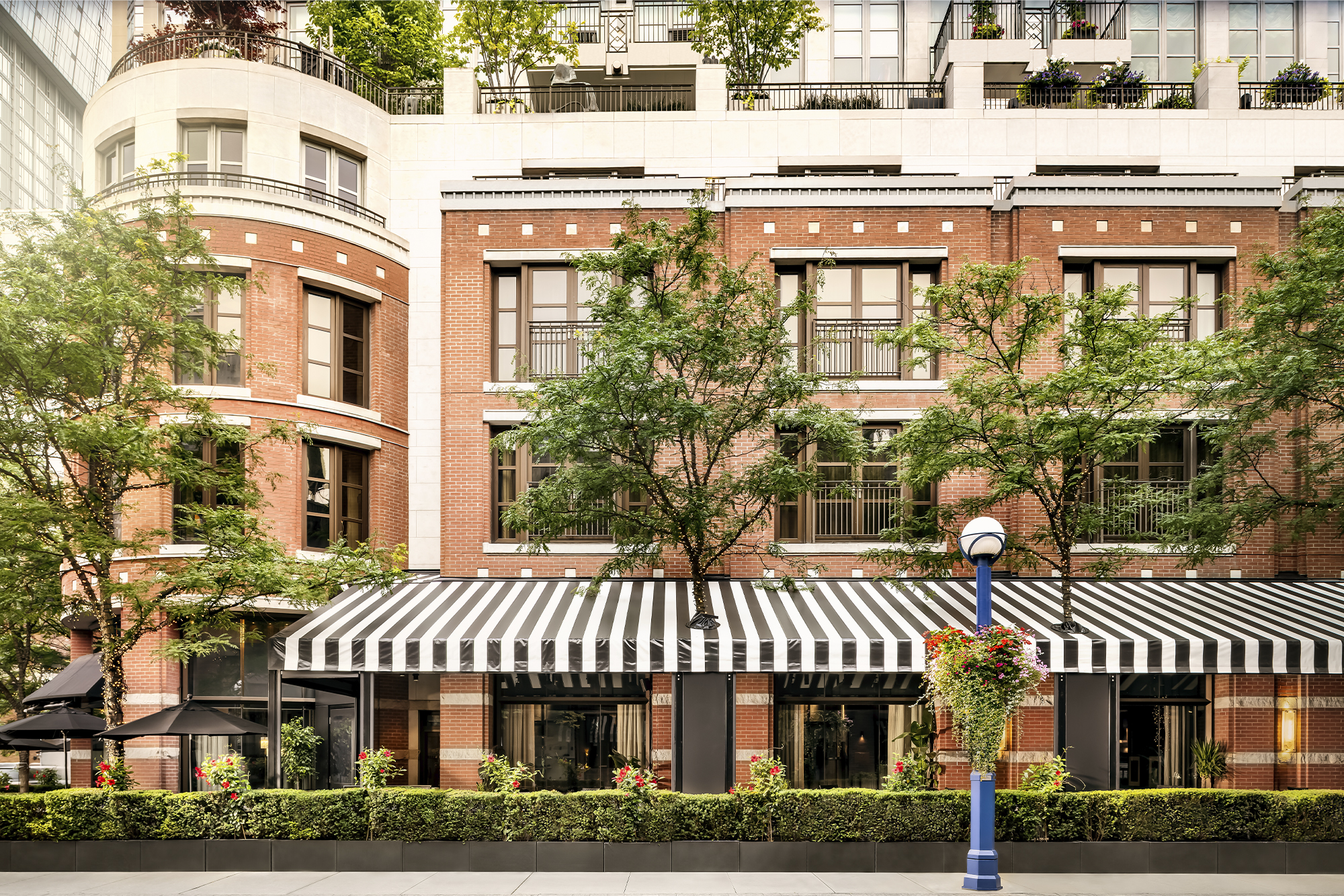 Exterior of Hazelton Hotel in the daytime, with an awning over the patio of ONE Restaurant and Bar, located inside The Hazelton Hotel. Photo courtesy of ONE Restaurant and Bar.