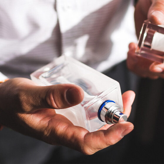 Scent Layering for Men photo shows man holding a bottle of cologne