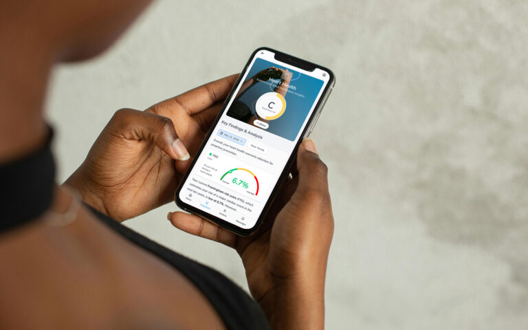 Woman Holding NiaHealth App on Phone (Outdoors)