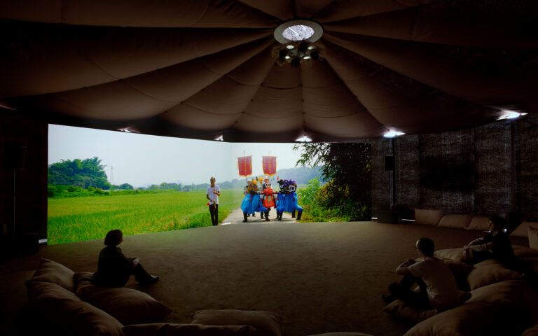 Exhibition view of “Dash” by Cao Fei Photo: Marta Marinotti and Federico Floriani Courtesy Fondazione Prada Cao Fei Dash, 2026 Multimedia installation, variable dimensions A 47’05” double-screen video, 9 surrounding photography installations, paddy field structures, weather stations, XAG agricultural drones, unmanned vehicles and promotional clips, furniture Structure of the installation developed by Small Production Courtesy of the Artis, Vitamin Creative Space and Sprüth Magers Work produced by Fondazione Prada on the occasion of the exhibition “Dash”