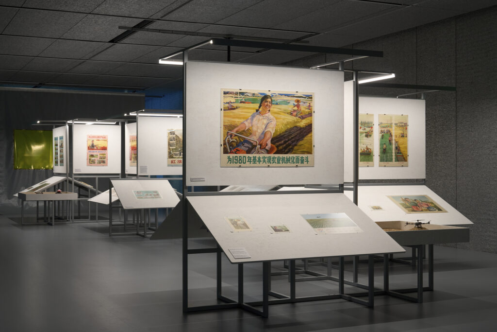 Exhibition view of “Dash” by Cao Fei Photo: Marta Marinotti and Federico Floriani Courtesy Fondazione Prada Cao Fei Land Evolution, 2026 Mixed-media installation, variable dimensions Historical documents (posters, wall charts, photographs, books, films) from different periods and media related to 1949 People’s Republic of China, XAG product models Documentary materials from Private Collection Structure of the installation developed by Small Production Courtesy of the Artist Work produced by Fondazione Prada on the occasion of the exhibition “Dash”