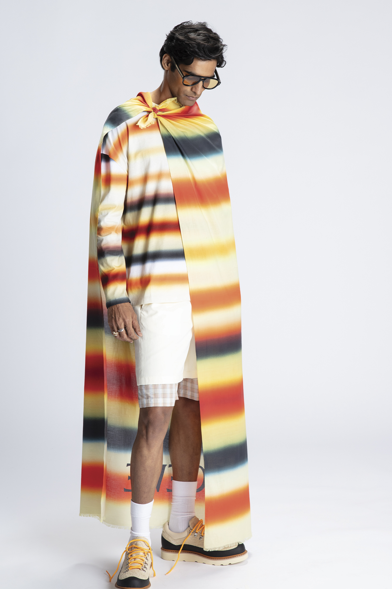 SHIRT ($1,100), SCARF ($690), SHORTS ($1,150), AND SHORTS ($1,300) BY LOEWE; SHOES ($190) BY SOREL; SOCKS ($16) BY KOTN; SUNGLASSES ($450) BY VIVEUR, AT HARRY ROSEN; RING ($2,880), RING ($10,700), AND BRACELET ($15,200) BY BVLGARI. Photo retrieved from SHARP Spring.