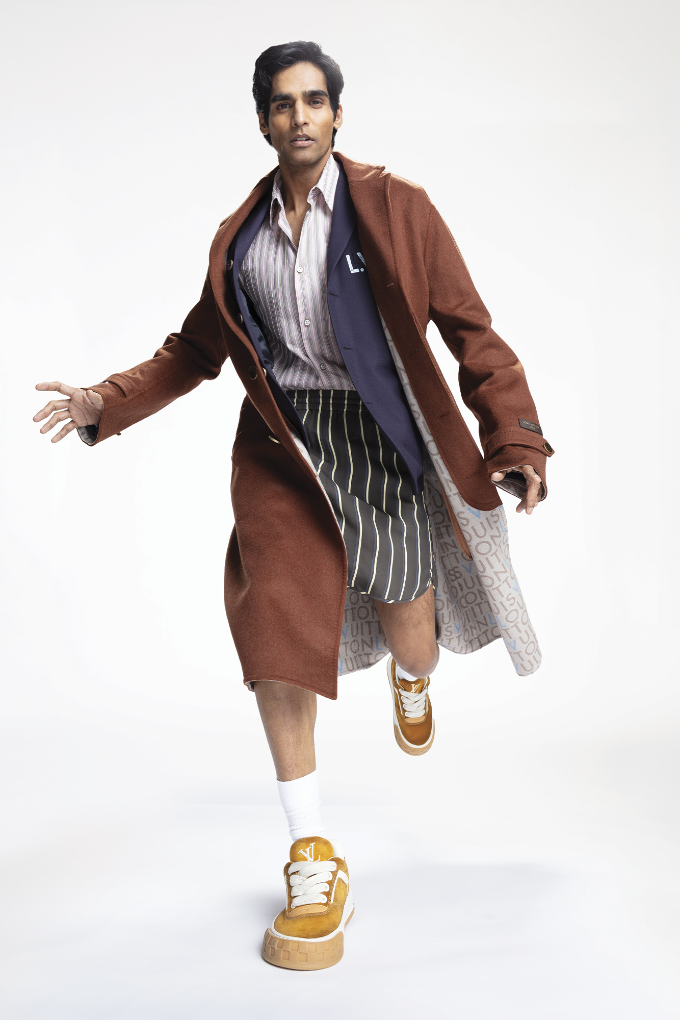 COAT ($6,800), JACKET ($4,600), SHIRT ($1,900), SHORTS ($1,510), AND SHOES ($1,570) BY LOUIS VUITTON MEN’S.